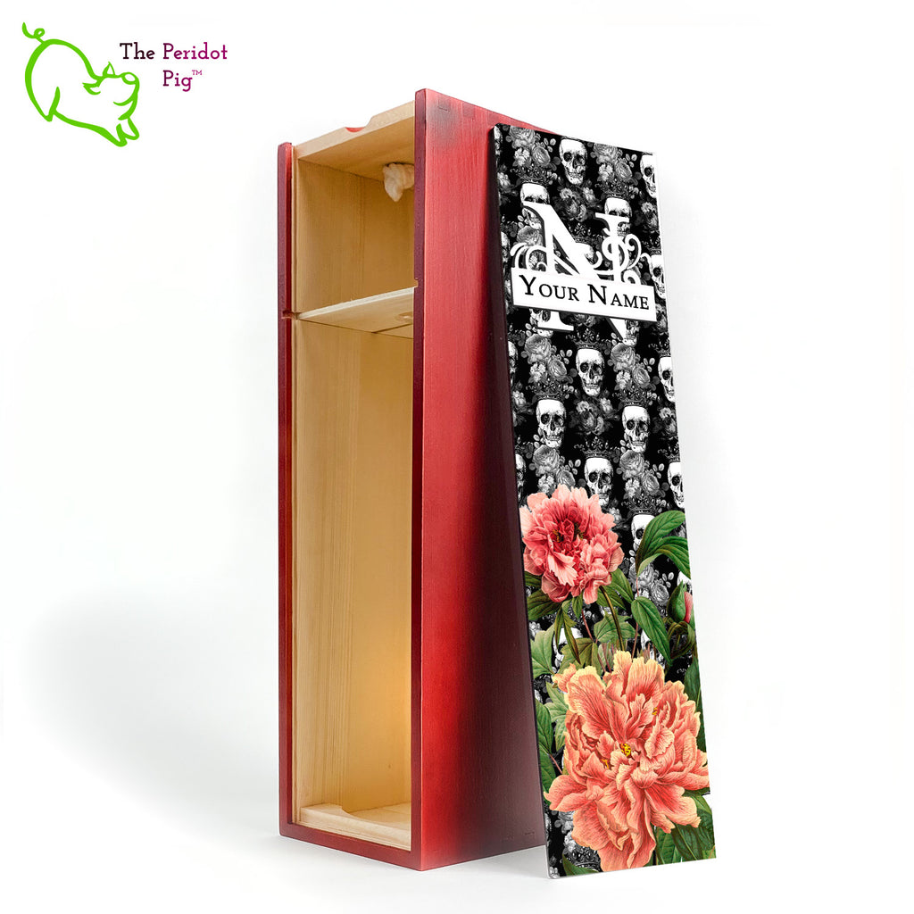 The front panel is decorated in a glossy, detailed print with a monogram and space for a customized name. This model has a background of Victorian skulls wearing a crown. in the foreground, there are two colorful peonies with green foliage. Front view in cherry showing the interior of the box.