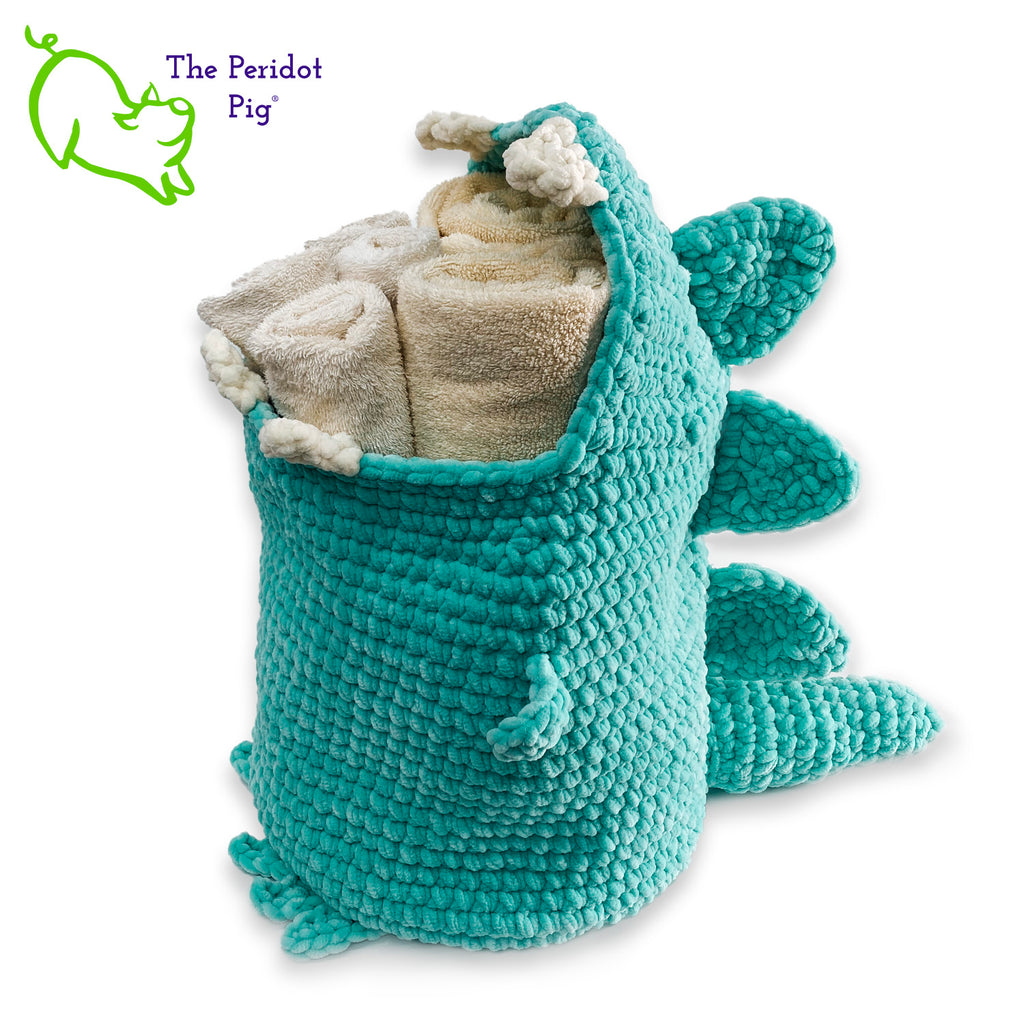 Hear Tiffany roar! Luckily she looks more menacing than reality. She's soft and plush from being made with a soft poly chenille. She just wants a hug but she has these little tiny arms which make it hard. Even her teeth and spikes are soft! As you can see, Tiffany has a big mouth that can hold a lot of toys, towels, clean diapers, even toilet paper (we put in 9 double rolls!). Left view shown filled with towels.