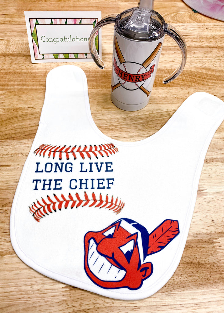 A sample of the baby bibs shown with a sippy cup and card.