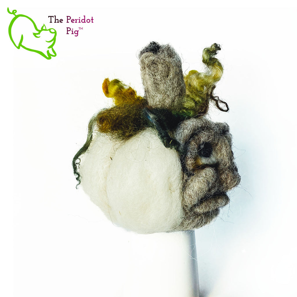 Just in time for the Halloween season, we're offering these one-of-a-kind pumpkins. We call them PolterPumpkins due to their ghostly, grotesque inspired faces. Each one is unique and hand-made from needle felted 100% wool. The pumpkin measures about 4-5" wide and around 4-5" tall. The body is crafted in white wool with the face in a stony gray. Multi-color locks simulate a little vine growth at the top. Right view - Fred.