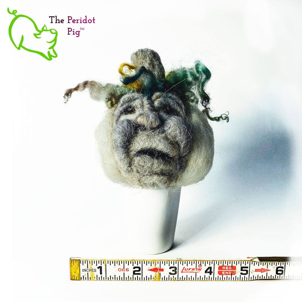 Just in time for the Halloween season, we're offering these one-of-a-kind pumpkins.  We call them PolterPumpkins due to their ghostly, grotesque inspired faces. Each one is unique and hand-made from needle felted 100% wool. The pumpkin measures about 4-5" wide and around 4-5" tall.  The body is crafted in white wool with the face in a stony gray. Multi-color locks simulate a little vine growth at the top. Front view - Geoff with ruler