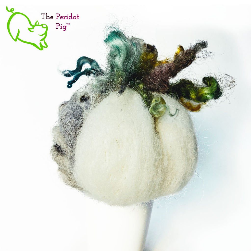 Just in time for the Halloween season, we're offering these one-of-a-kind pumpkins.  We call them PolterPumpkins due to their ghostly, grotesque inspired faces. Each one is unique and hand-made from needle felted 100% wool. The pumpkin measures about 4-5" wide and around 4-5" tall.  The body is crafted in white wool with the face in a stony gray. Multi-color locks simulate a little vine growth at the top. Left view - Geoff.
