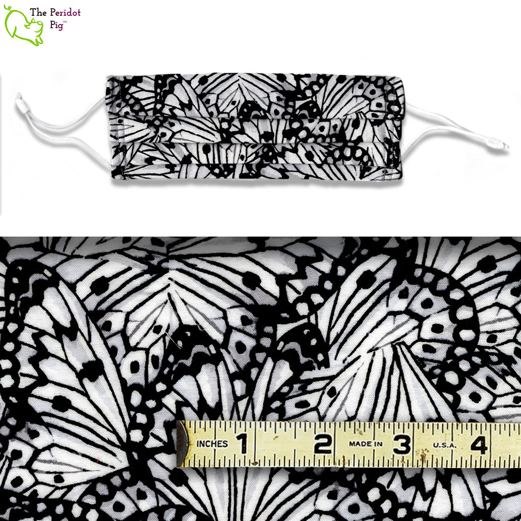 View showing the mask and swatch of fabric.The Butterfly Wings fabric is a mix of black and white with a touch of grey in stylized monarch butterfly wing pattern. 