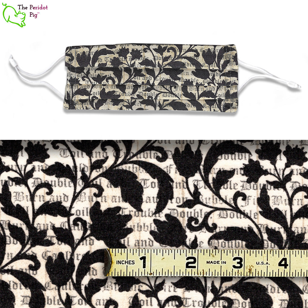 Double, double toil and trouble; Fire burn and caldron bubble. These masks called Macbeth have the famous quote overlaid with black scrolling vines. A view of the mask and the fabric scale.